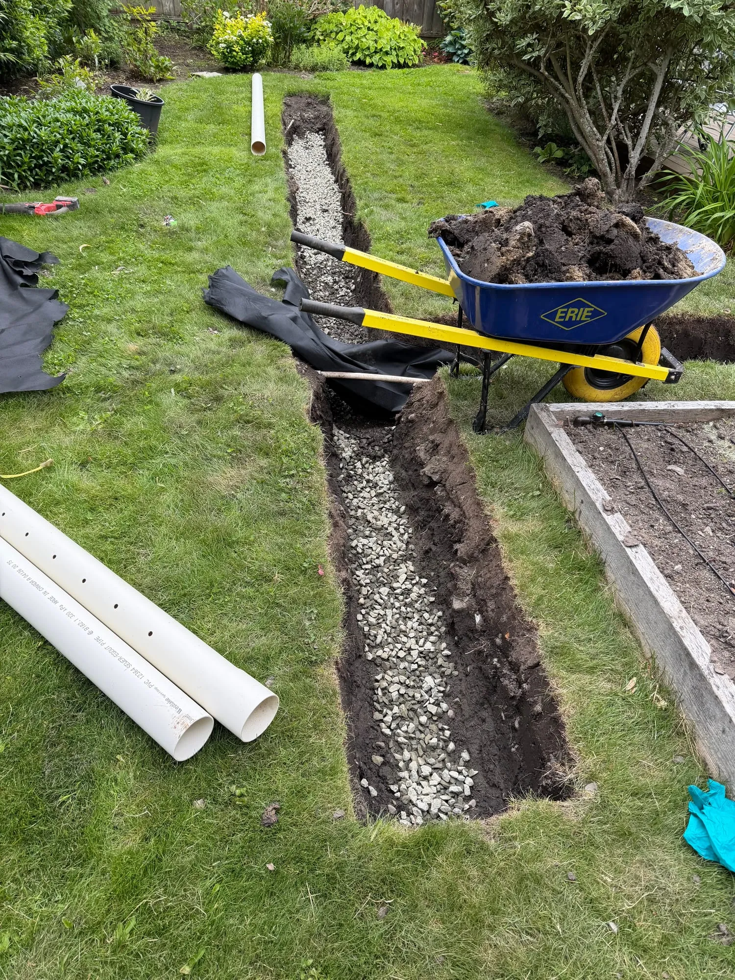 Filter cloth lining the trench, then the crushed rock base and perforated pipe.